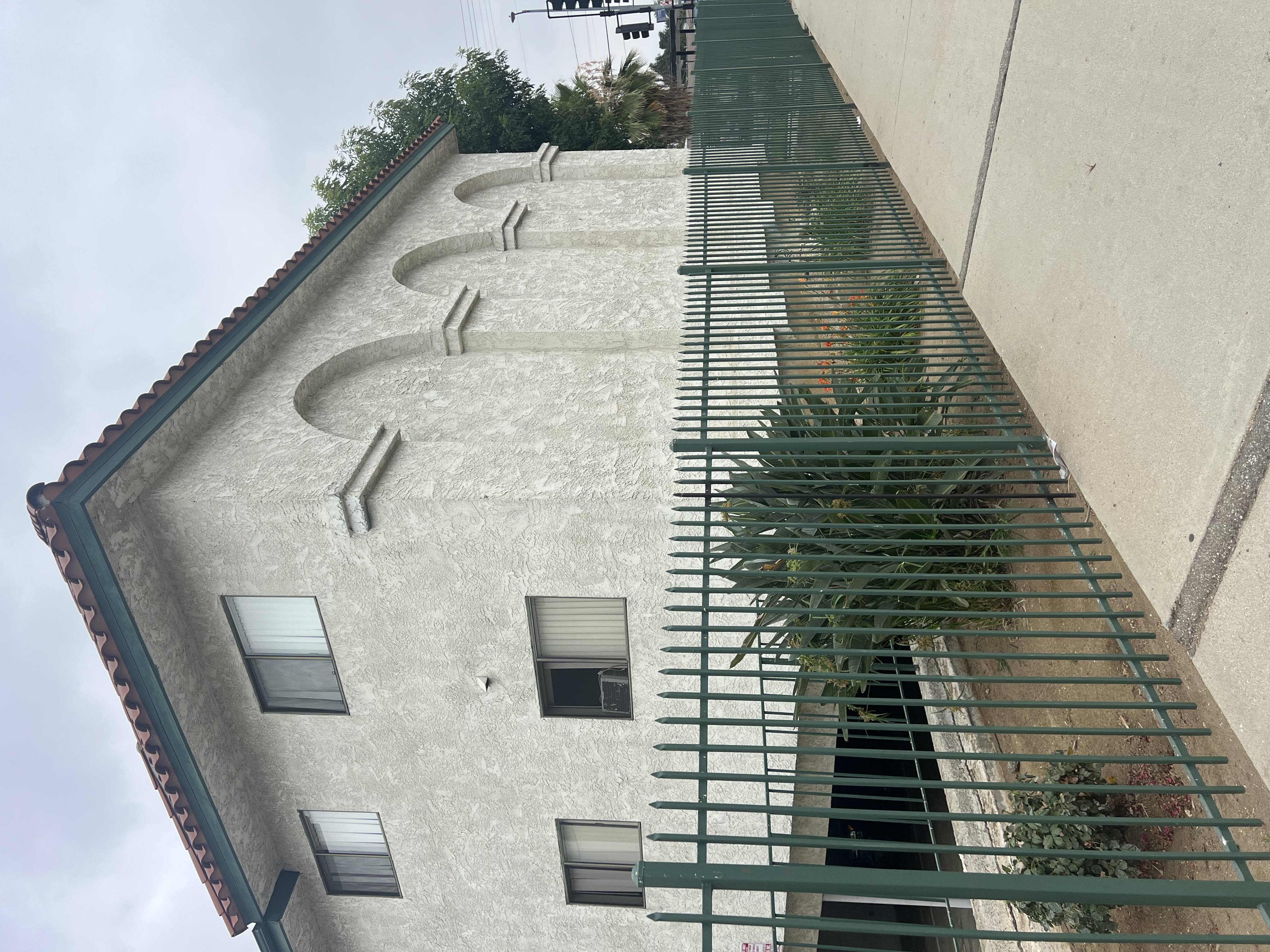 A building with a green fence in front of it.